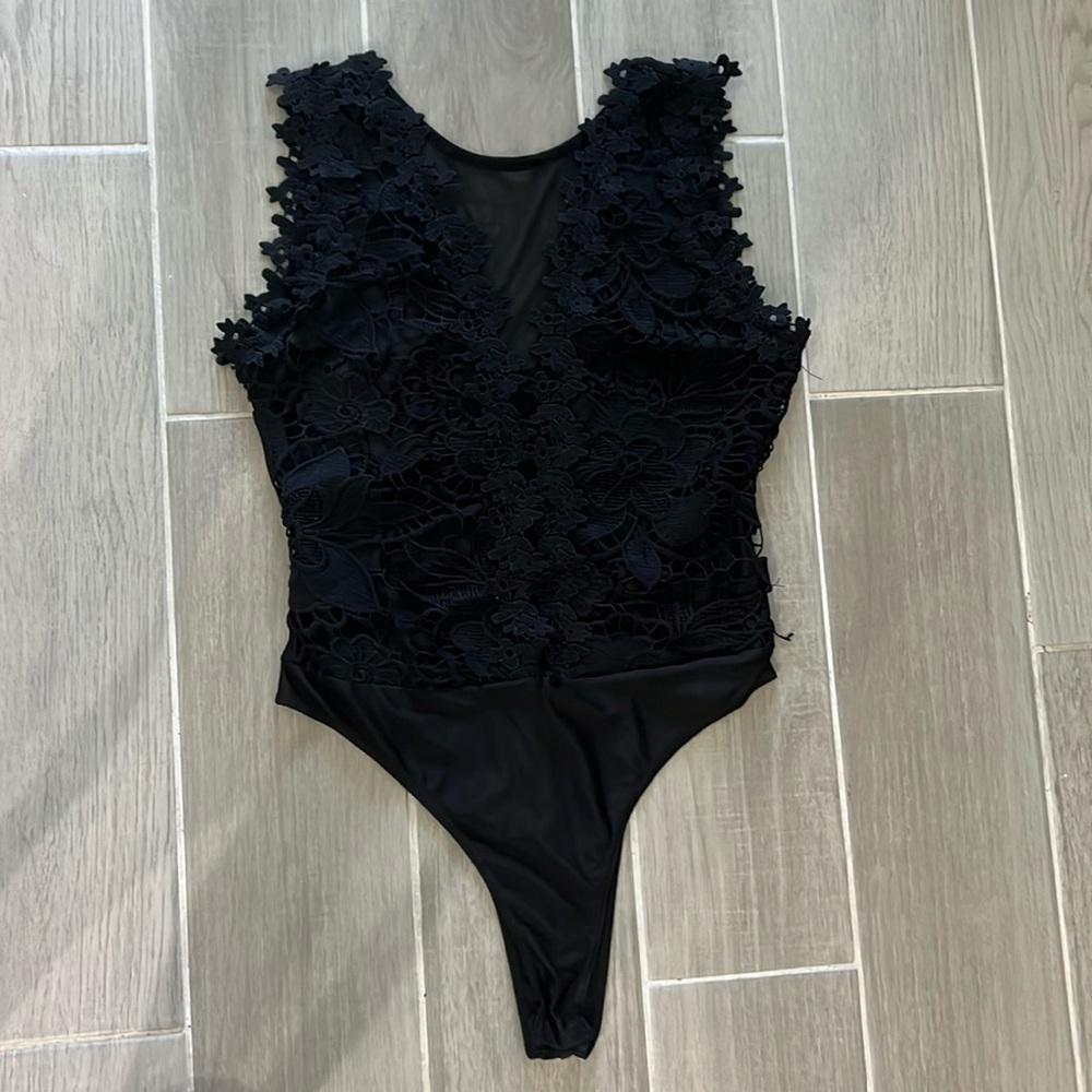 Black body suit with sheer, deep V and floral appliqué